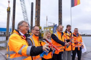 Verfolgten gespannt den ersten Rammschlag (v.l.n.r.): Holger Banik (Geschäftsführer der Niedersachsen Ports GmbH & Co. KG); Grant Hendrik Tonne (Niedersächsischen Minister für Wirtschaft, Verkehr; Alexandra Brandt, (stv. Niederlassungsleiterin Cuxhaven und Stade der Niedersachsen Ports); Uwe Santjer (Oberbürgermeister der Stadt Cuxhaven); Volker Weiß (Geschäftsführer der Niedersachsen Ports); Knut Kokkelink (Niederlassungsleiter Cuxhaven und Stade der Niedersachsen Ports)